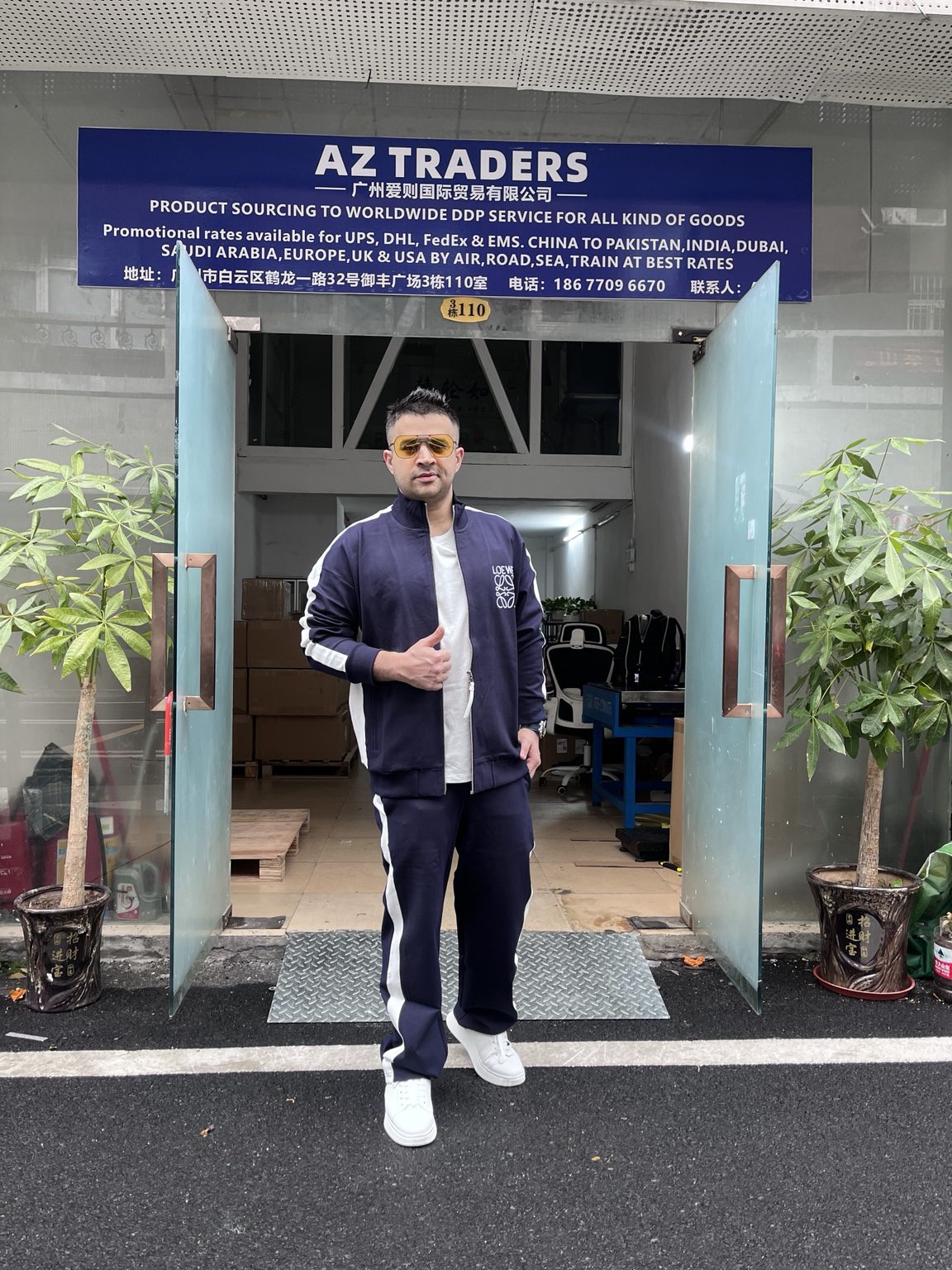 Syed Siraj Hussain outside the AZ TRADERS office in Guangzhou, with company signage visible