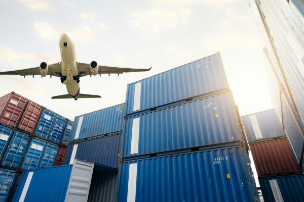 Air logistics. Cargo airplane flying above stack of logistic container. Cargo and shipping business. Air logistics. Cargo airplane flying above stack of logistic container. Cargo and shipping business.